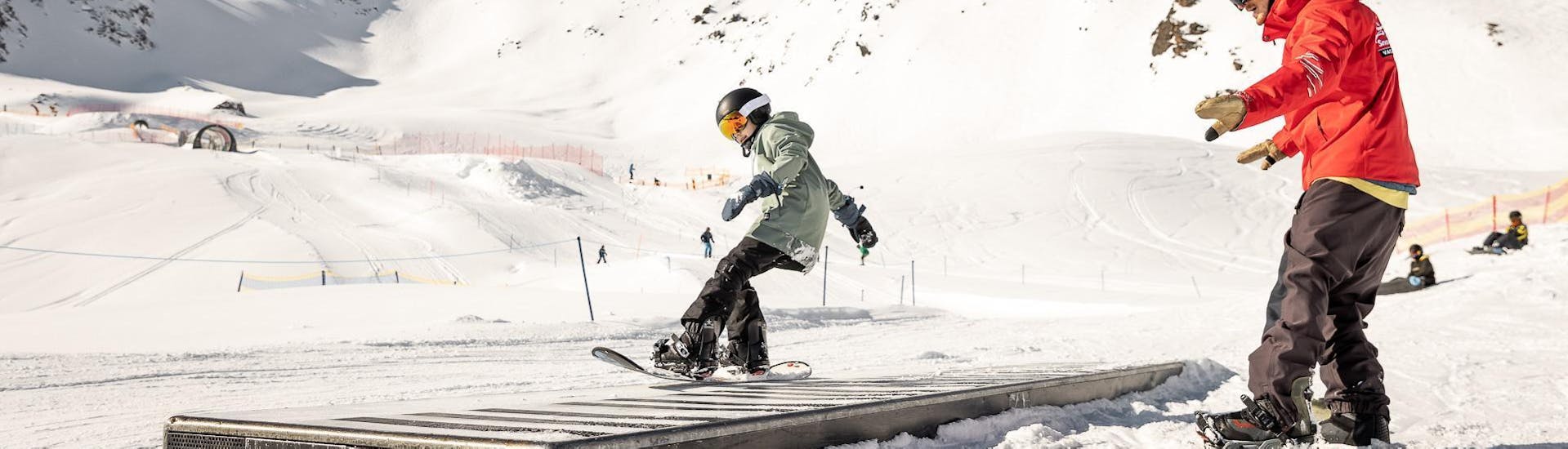 A young snowboarder is practicing new tricks during his Private Snowboarding Lessons for Kids - All Levels with the ski school Ski- und Snowboardschule Vacancia.