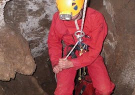Someone is making progress in a cave during their activity of Caving in Spectaclan for Families with Geo Ardèche Canyon.