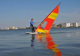 Windsurfkurs für Anfänger in Heiligenhafen mit Wassersportcenter Heiligenhafen Ein Windsufer auf dem See beim Windsurfen für Anfänger in Heiligenhafen mit dem Wassersportcenter Heiligenhafen.