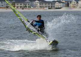 Windsurfingkurs für Fortgeschrittene - Heiligenhafen mit dem Wassersportcenter Heiligenhafen Ein Windsurfer hat Spaß auf dem See während des Windsurfing-Kurses für Fortgeschrittene - Heiligenhafen mit dem Wassersportcenter Heiligenhafen.