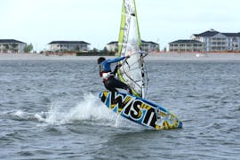 Ein Windsurfer macht Tricks während des Windsurfing-Kurses "SAC Step Pro" - Heiligenhafen mit dem Wassersportcenter Heiligenhafen.
