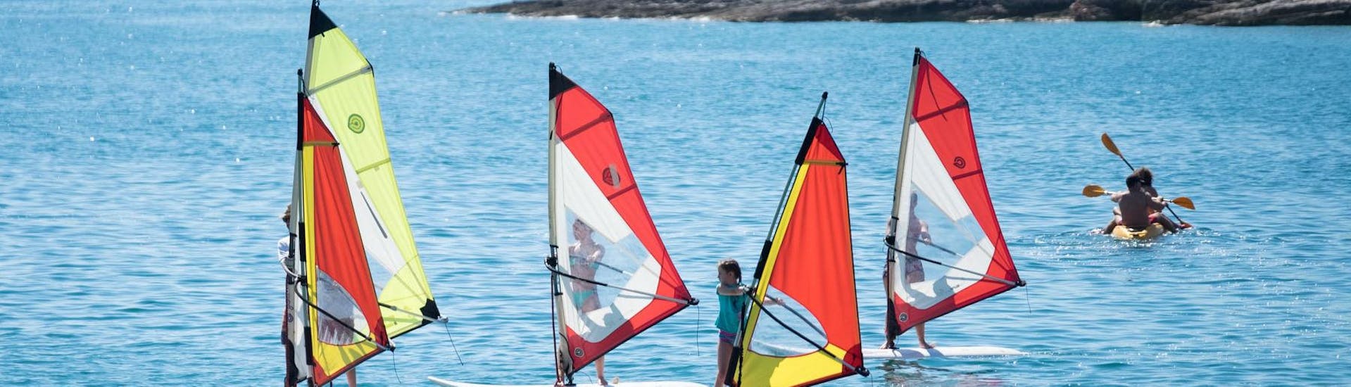 A group of people enjoying during a Windsurfing Lessons (8+ y.) at Školjić Beach for Beginners with Windsurf Station Premantura.