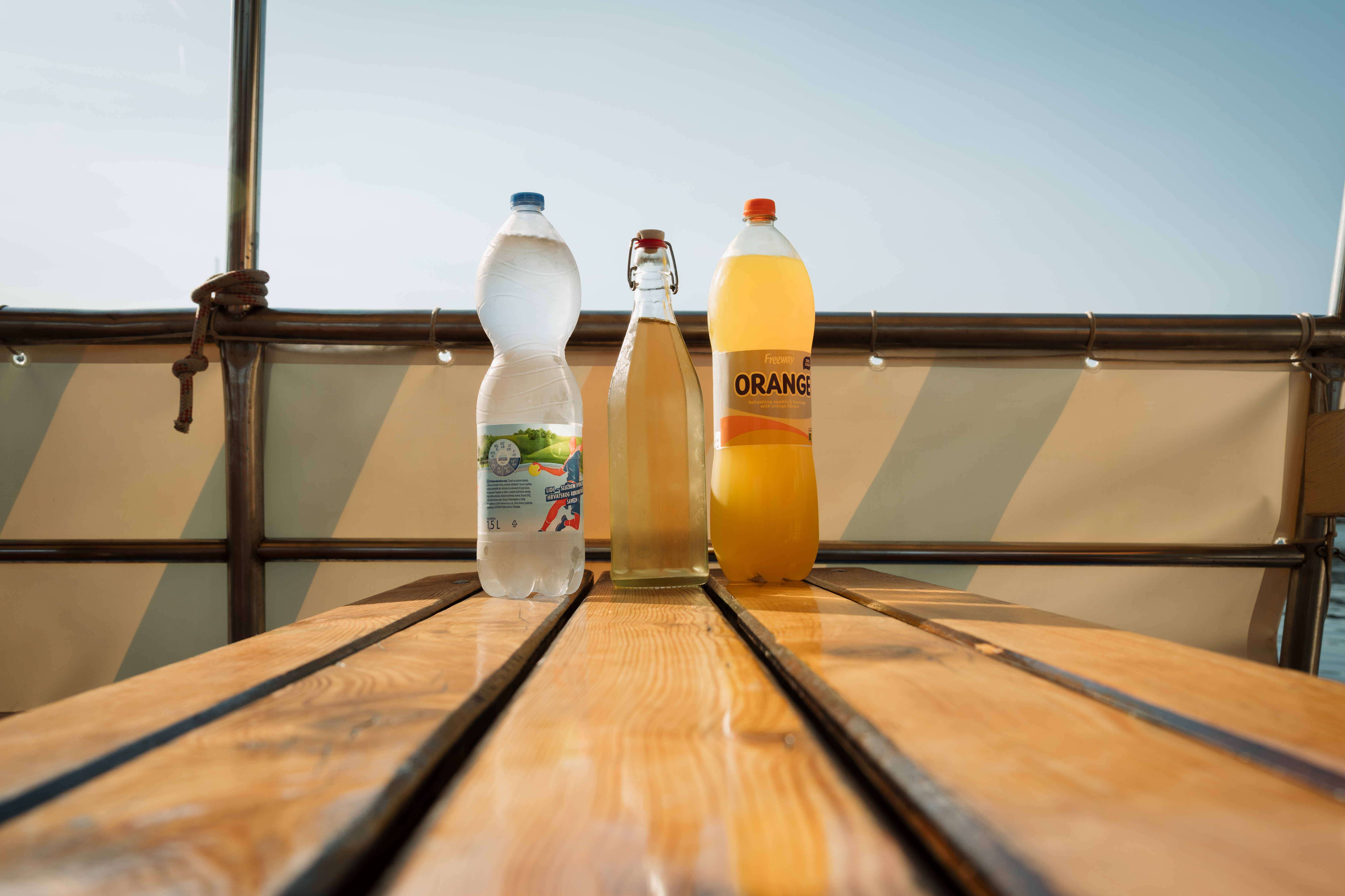 Durante un soleado paseo en barco desde Vrsar a Rovinj y el fiordo de Lim con Lidija Tours Vrsar, podrá disfrutar de bebidas refrescantes sobre una mesa de madera.