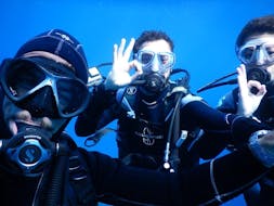 Three persons taking a selfie during trial scuba diving in Baie de Calvi in Corsica with Calvi Plongée.