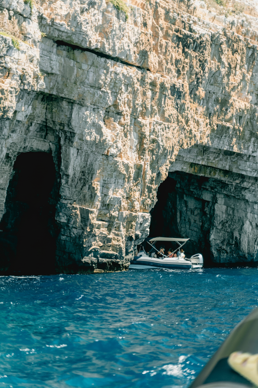 Una piccola imbarcazione turistica della Toto Travel Split entra nella Grotta Azzurra durante l'escursione in barca alle 6 isole con partenza da Spalato.