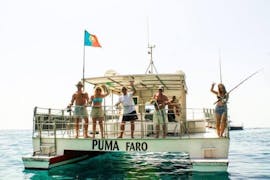 De passagiers van de boottocht naar de rotsen en grotten van Benagil vanuit Vilamoura, georganiseerd door Cruzeiros da Oura Vilamoura, zwaaien naar de camera terwijl ze op weg zijn naar zee.