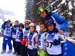 Kinder zeigen stolz ihre Medaille nach dem erfolgreichen Rennen während dem Kinder Skikurs (6-12 Jahre) - Ganztags - Alle Levels mit der Skischule Zugspitze-Grainau.