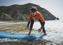 Surfing Lessons (from 6 y.) on Praia Castelejo with Good Feeling Surf School Algarve. A child on a surfboard during Surfing Lessons (from 6 y.) on Praia Castelejo with Good Feeling Surf School Algarve.