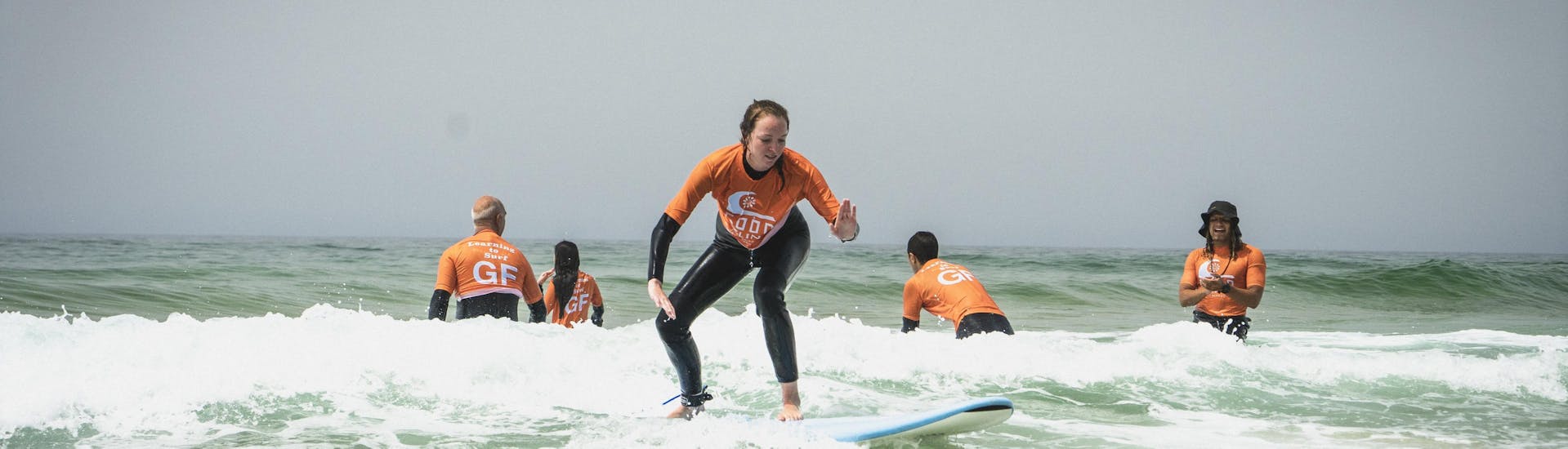 Un grupo de participantes en tablas de surf durante las clases de surf (a partir de 6 años) en Praia Castelejo con Good Feeling Surf School Algarve.