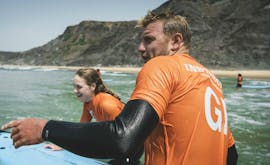 Twee deelnemers bekijken iets tijdens privé surflessen (vanaf 6 j.) op Praia Castelejo met Good Feeling Surf School Algarve.