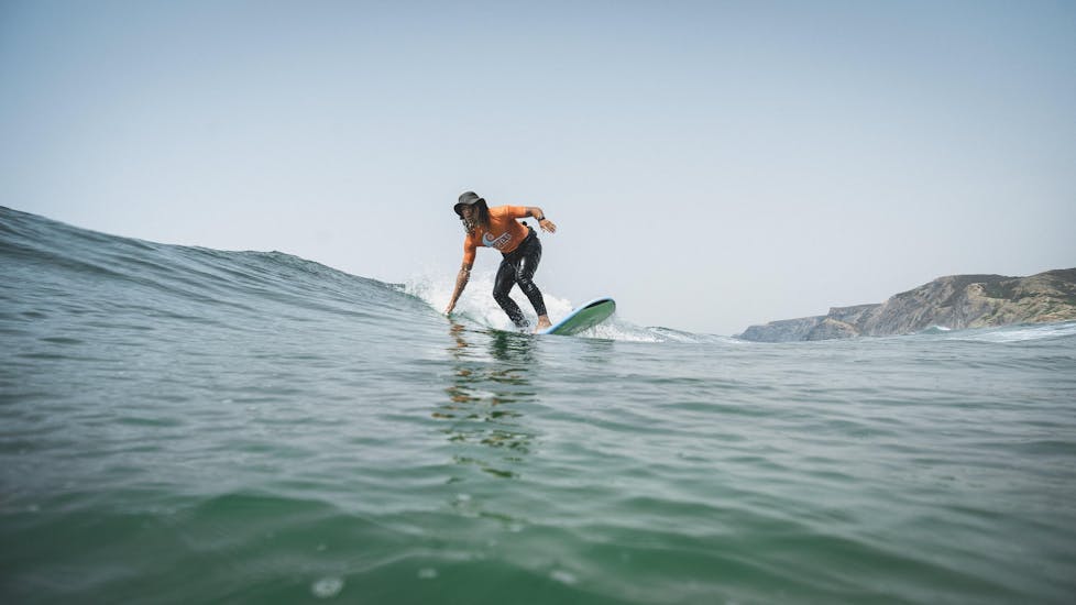 Un partecipante che cavalca una piccola onda durante le lezioni private di surf (dai 6 anni) a Praia Castelejo con la Good Feeling Surf School Algarve.
