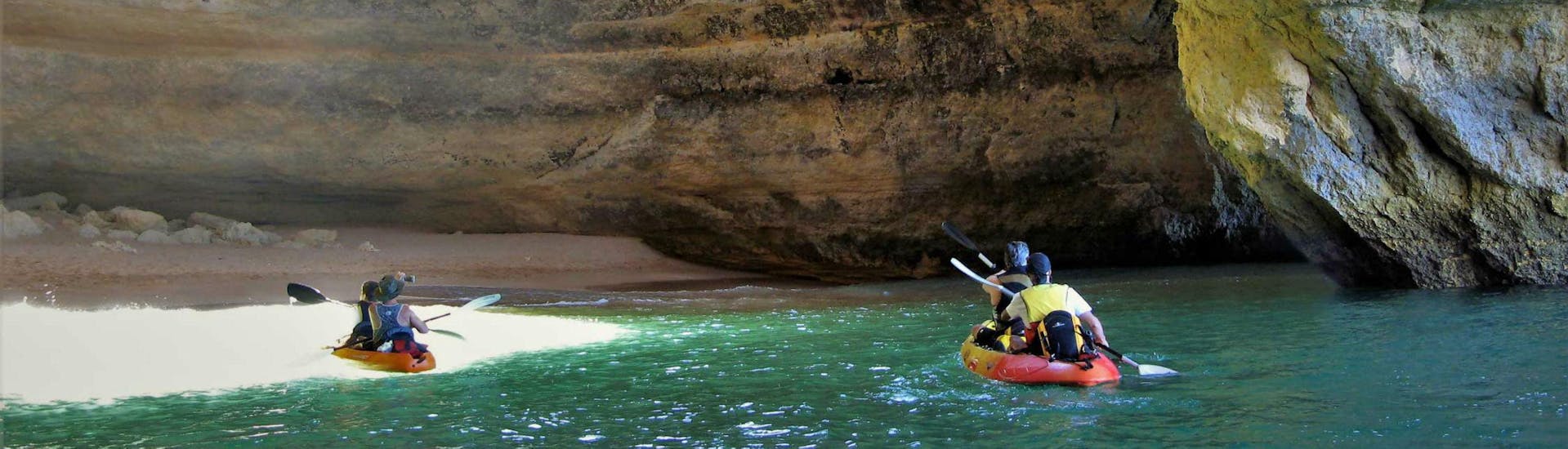 Un groupe de kayakistes pagaie dans la grotte de Benagil pendant leur balade en bateau et en kayak - grotte de Benagil avec Seasiren Tours.