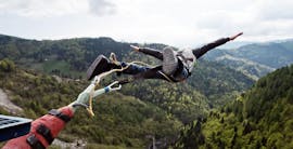 Un uomo sta saltando durante il Bungee Jumping dal Ponte di Valgadena (175m) con Bungy X Team Valgadena.