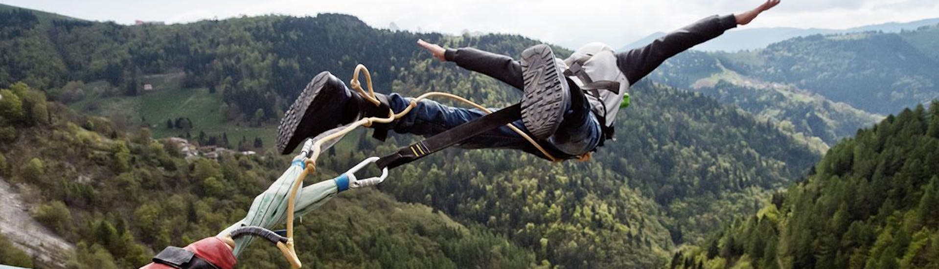 Un uomo sta saltando durante il Bungee Jumping dal Ponte di Valgadena (175m) con Bungy X Team Valgadena.