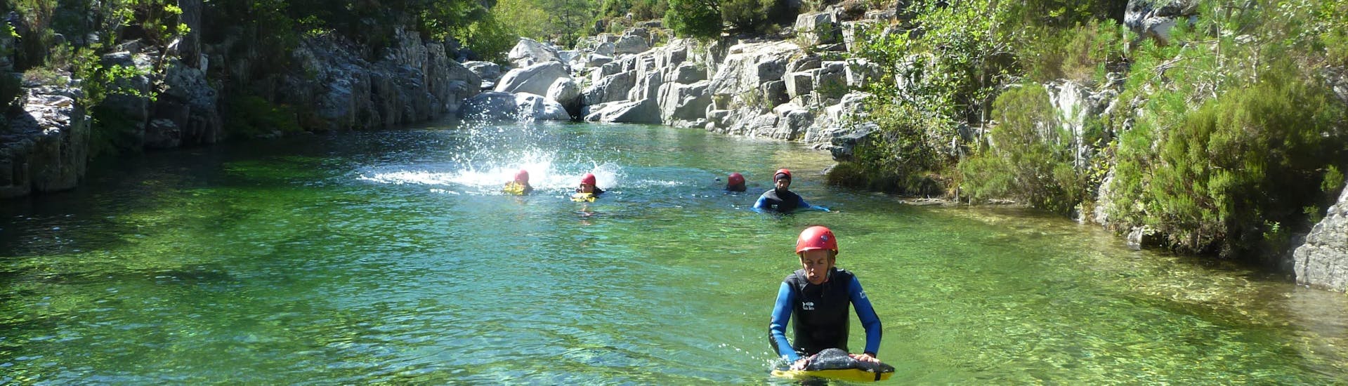 A group is swimming in the canyon du Tavignano during the Canyoning Full day with Canyon Corse.