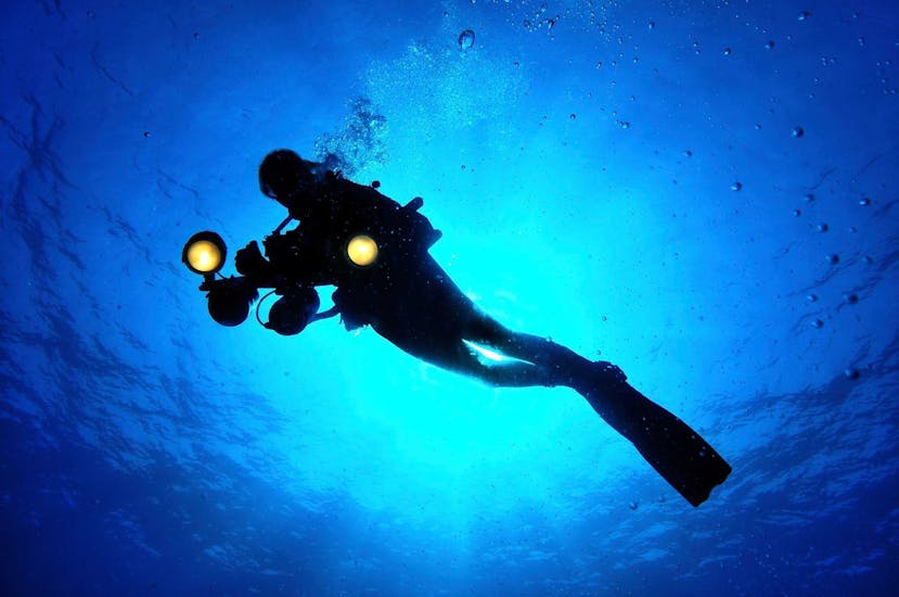 A tourist is swimming during his trial scuba diving for beginners in l'île rousse with EPIR Plongée.
