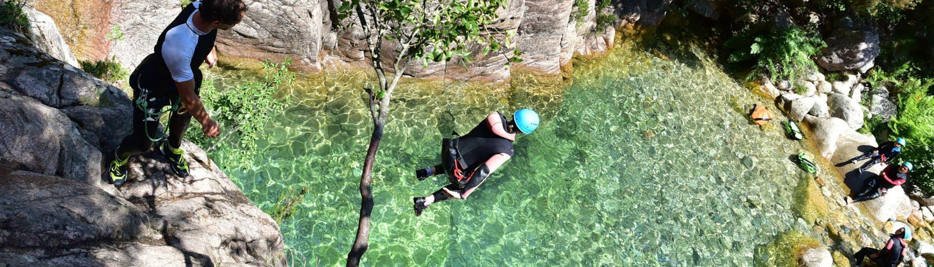 A man is jumping in a natural pool during a Private Canyoning in Vacca - Aquatic (12 ppl max) trip with Corsica Madness.