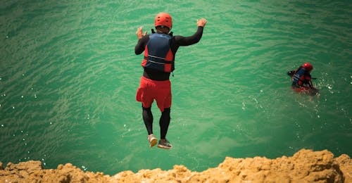 Coasteering ad Albufeira - Avventure costiere con Albufeira Surf & SUP Un uomo che salta in acqua durante il Coasteering ad Albufeira - Avventure costiere con Albufeira Surf & SUP.