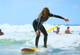Einer Surferin gelingt es, dank ihres Surfunterrichts am Strand der Côte des Basques mit La Vague basque eine Welle zu surfen.