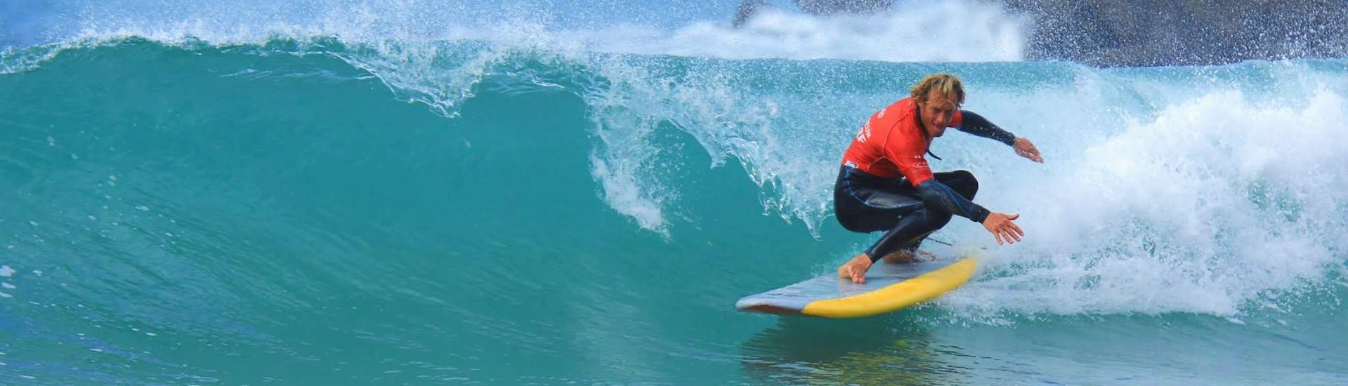Een surfster slaagt erin op een golf te surfen dankzij haar surflessen op het strand van de Côte des Basques met La Vague basque.