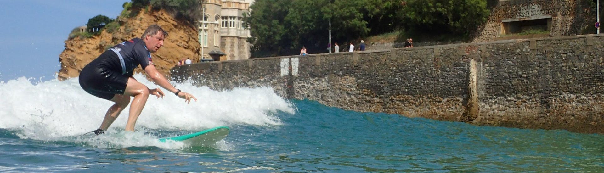 Un surfeur se prépare à prendre une vague lors d'un cours de surf privé sur la plage de la Côte des Basques avec La Vague basque.