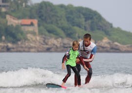A boy is having Surfing Lessons for Kids (5-7 years) - Hendaye Beach with Gold Coast Hendaye.