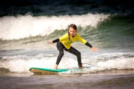 A girl enjoying her Private Surf Lessons (from 5 y.) at Guincho Beach in Cascais with Moana Surf School Cascais.