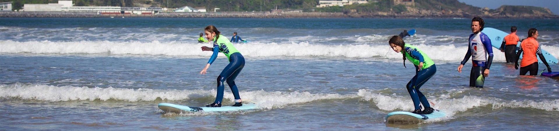 2 young girls are learning how to surf during their Weekend Surf Lessons (from 7 y.) on Hendaye Beach with Gold Coast Surf School Hendaye.