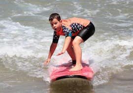 Wochenend-Surfunterricht (ab 7 J.) am Strand von Hendaye mit Gold Coast Surf School Hendaye Ein Kind lernt Surfen während eines Surfkurses "Weekend" - Hendaye Beach - All Levels mit Gold Coast Hendaye.