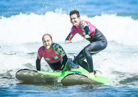 2 men are learning surf thanks to a surfing lesson  for Kids & Adults with ocean beach in Hendaye.