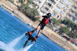 A person standing on a board above the water during Flyboarding in Spinola Bay in St. Julian's with Flyboard Malta Ltd.