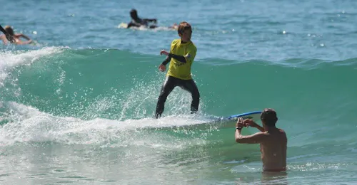 Cours privé de surf (dès 6 ans) sur la plage Sud à Hossegor avec Tao Magic Glisse Surf School Hossegor Un enfant effectue un cours de surf privé en basse saison sur la Plage Sud à Hossegor avec un moniteur de Tao Magic Glisse.