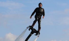 Een persoon staat op een board boven het water tijdens het Flyboarden in Spinola Bay in St. Julian's met Flyboard Malta Ltd.