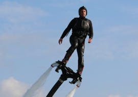 Une personne debout sur une planche au-dessus de l'eau lors d'une séance de Flyboard dans la baie de Spinola à St. Julian's avec Flyboard Malta Ltd.