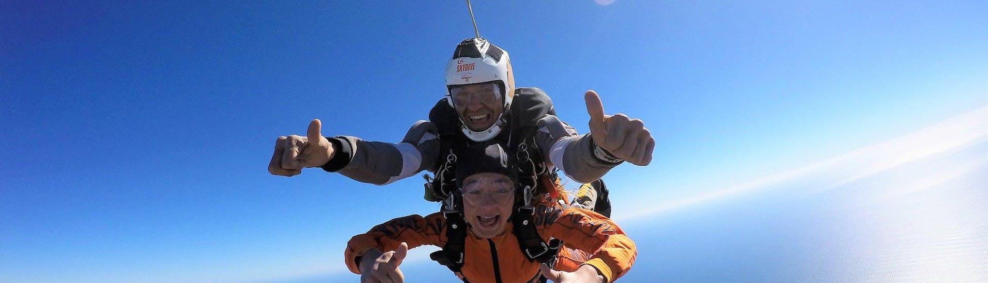 Ein junges Mädchen im freien Fall mit ihrem Lehrer während des Tandemfallschirmsprungs aus 15.000 Fuß (ca. 4,57 km) - Algarve mit Skydive Algarve.