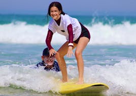 Ein Mädchen lernt das Surfen während ihres Surfkurs für Kinder (4-10 J.) in Lacanau mit Hurley Surf Club Lacanau.