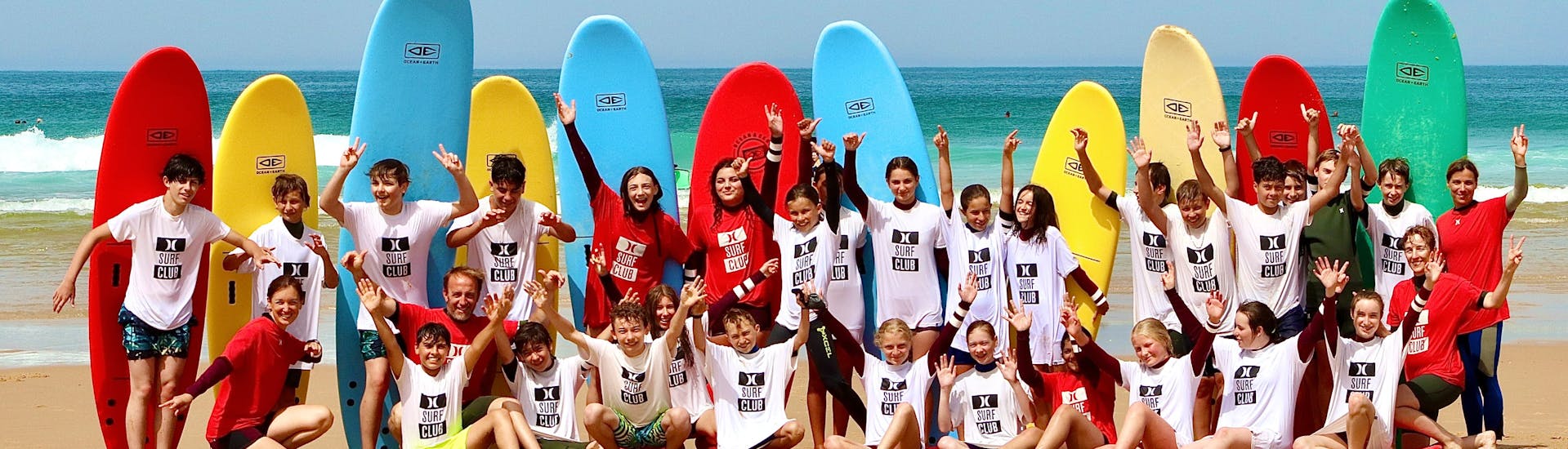 Surfers are taking a group picture after their Private Surf Lessons (from 5 y.) on Centrale Beach with Hurley Surf Club in Lacanau.