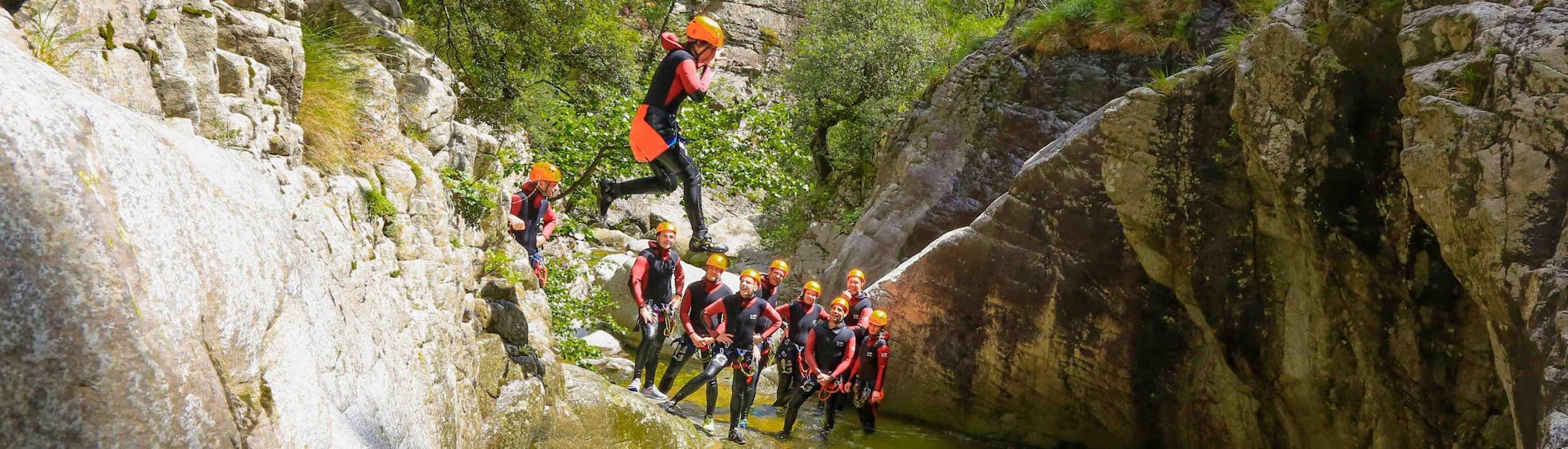 Un touriste saute dans le canyon de Zoicu lors de son activité canyoning pour les familles avec reves de cimes.