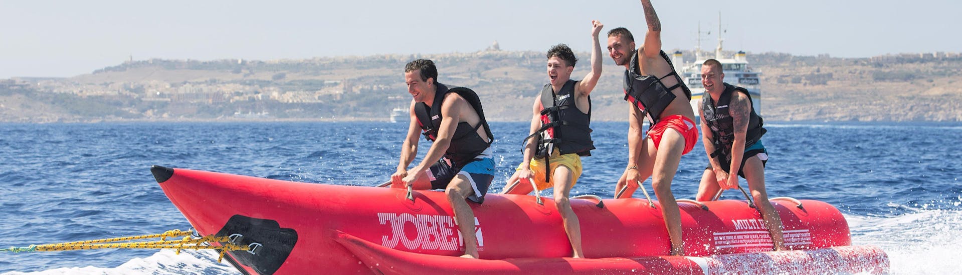 Groepsfoto tijdens de bananenboot rit in Armier Bay Beach met Palm Beach Water Sports Malta.