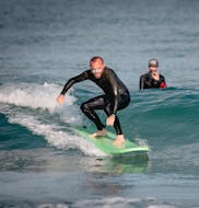 A surfer is learning how to surf a wave under the supervision of their surf instructor from the surf school ESCF Hossegor during their Surfing Lessons on the Gravière Beach.