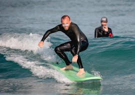 Een surfer leert hoe hij op een golf moet surfen onder toezicht van zijn surfinstructeur van de surfschool ESCF Hossegor tijdens hun surflessen op het strand van Gravière.