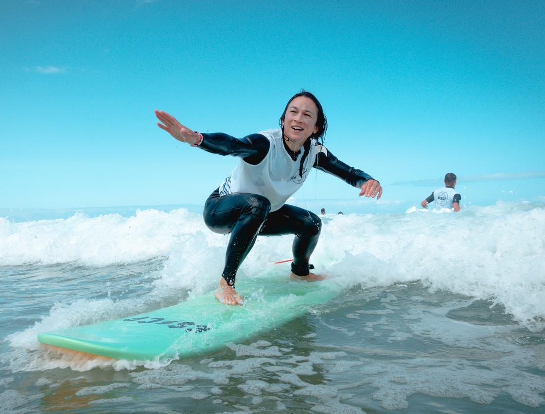 Een surfer neemt een kleine golf op de kust dankzij haar privé surflessen op het Gravière strand met ESCF Hossegor surfschool.