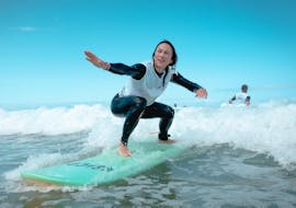 Eine Surferin nimmt eine kleine Welle während ihres privaten Surfunterrichts am Strand von Gravière mit der Surfschule ESCF Hossegor.