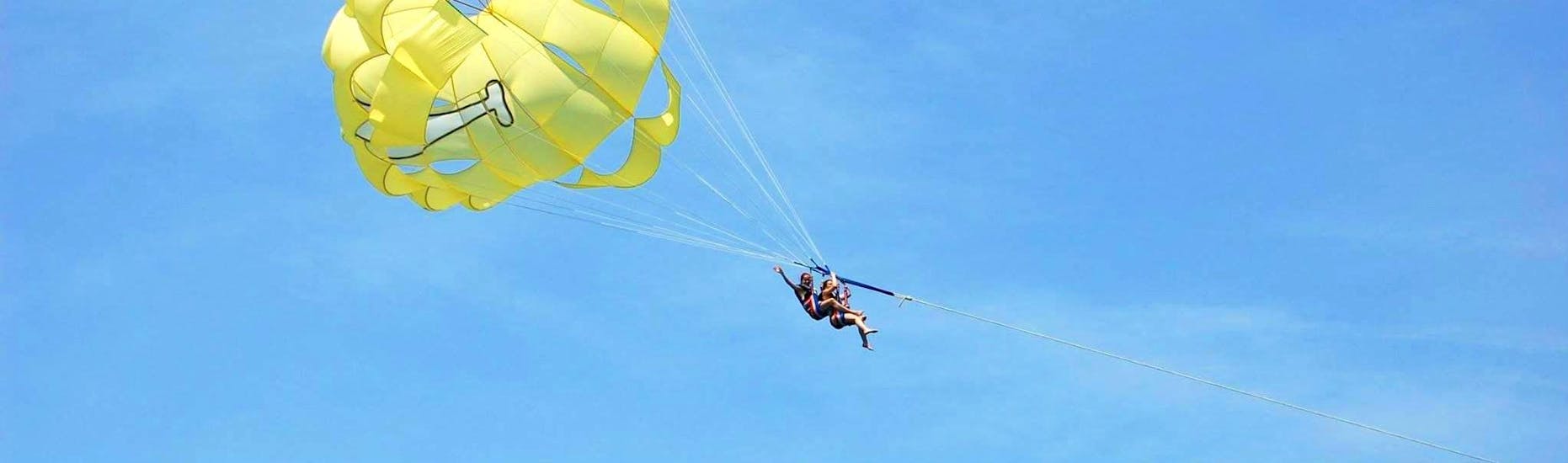 Friends are having fun while Parasailing in Villeneuve-Loubet with Plage des Marines.