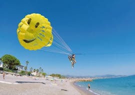 Friends are taking off from the beach while starting Parasailing in Villeneuve-Loubet with Plage des Marines.
