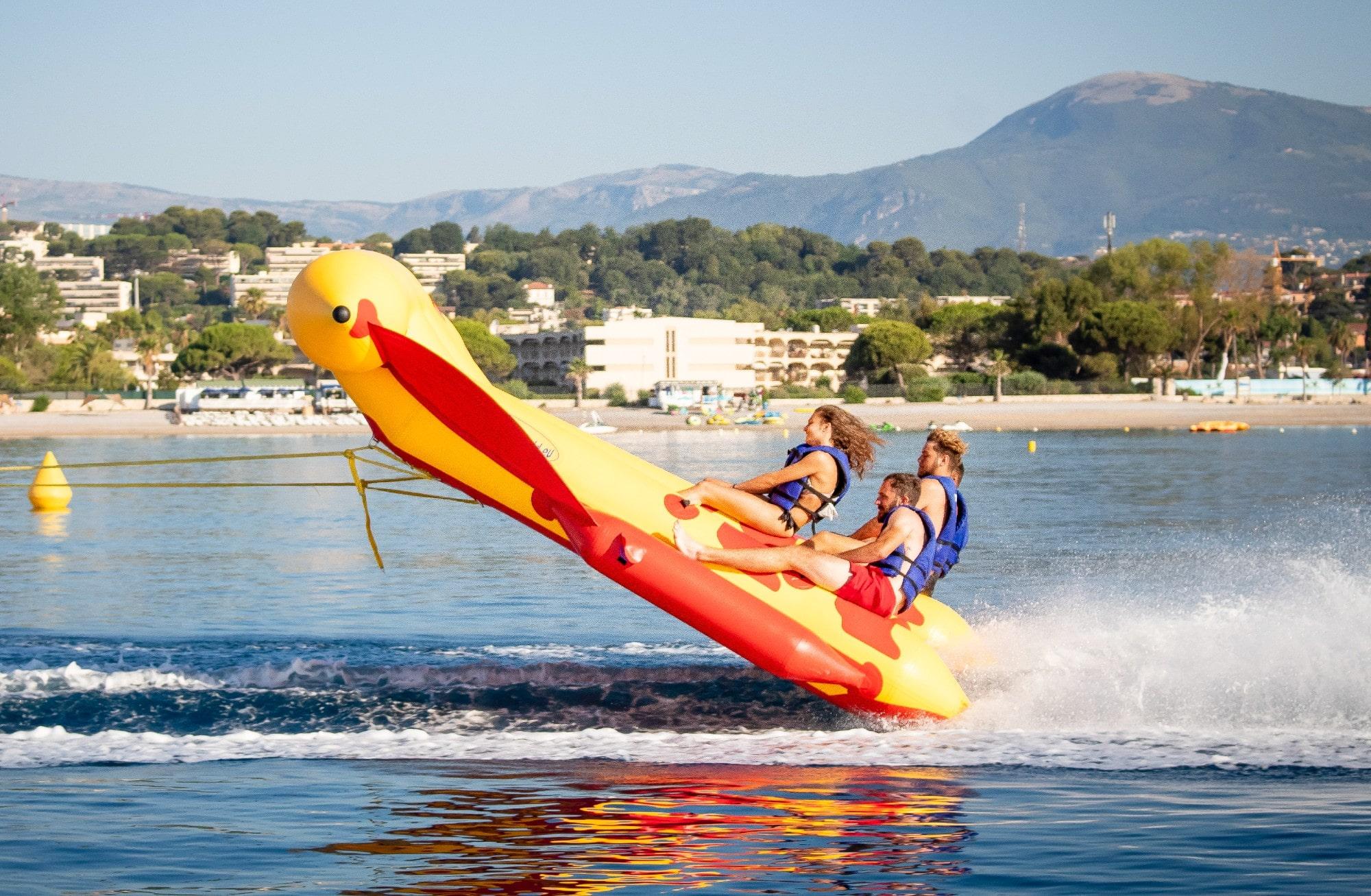Friends are having fun on their ride with an Inflatable Boat in Cagnes-sur-Mer with Plage des Marines.