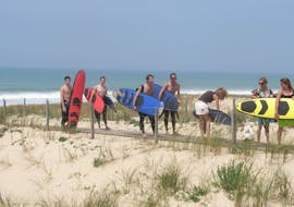 7 young people with their surfboards make the surfing lesson for all levels on the sail fish beach with nomad surf school.