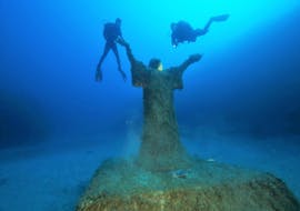 Deux plongeurs explorent la mer autour de la statue submergée du Christ des Abysses à Malte lors d'une Plongée d'Exploration depuis St Paul's Bay avec Octopus Garden.