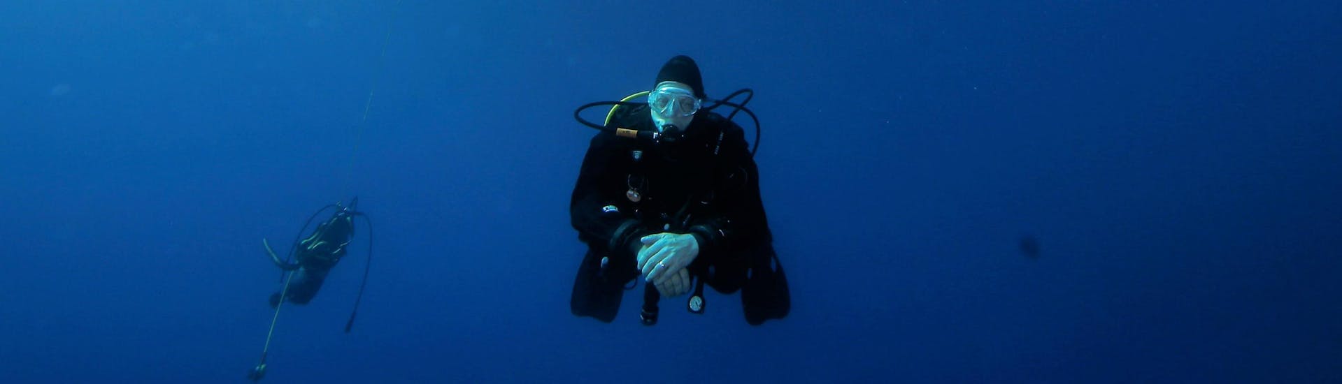 A participant of the Scuba Diving Course for Beginners - SSI Open Water Diver with Octopus Garden is diving in the blue ocean around Malta.