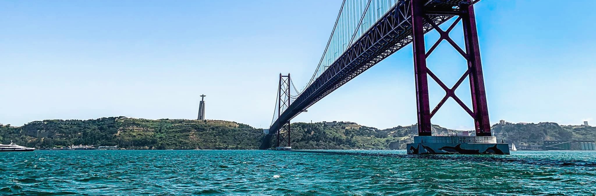View of the Ponte 25 de Abril during the private sunset boat trip on the Tagus from Torre de Belém with Rent a Boat Lisbon.